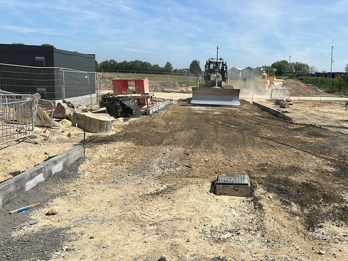 Dozer trimming road formation to level between set kerb lines