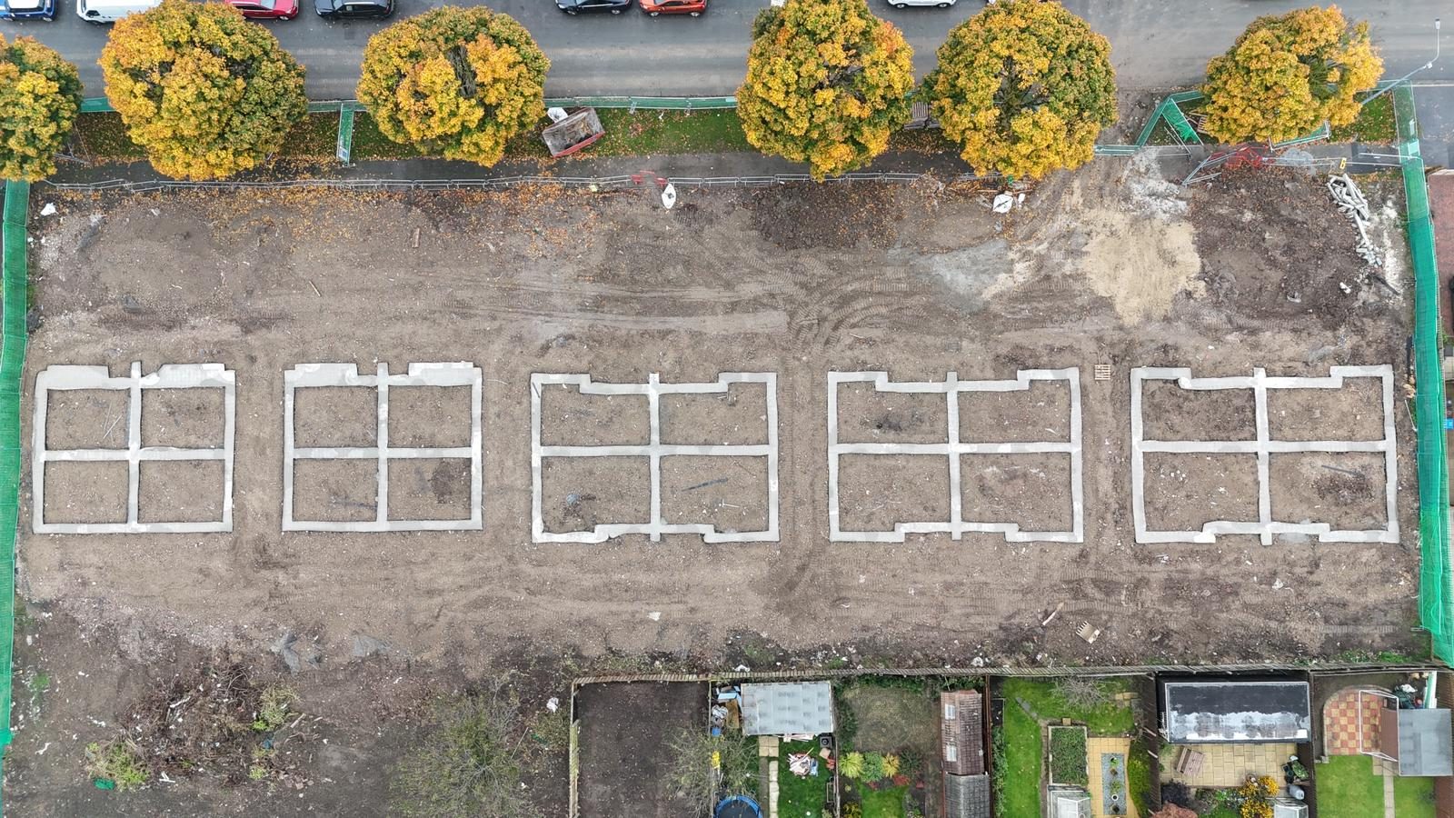Aerial view of a row of house plot strip foundations set out on a housing site
