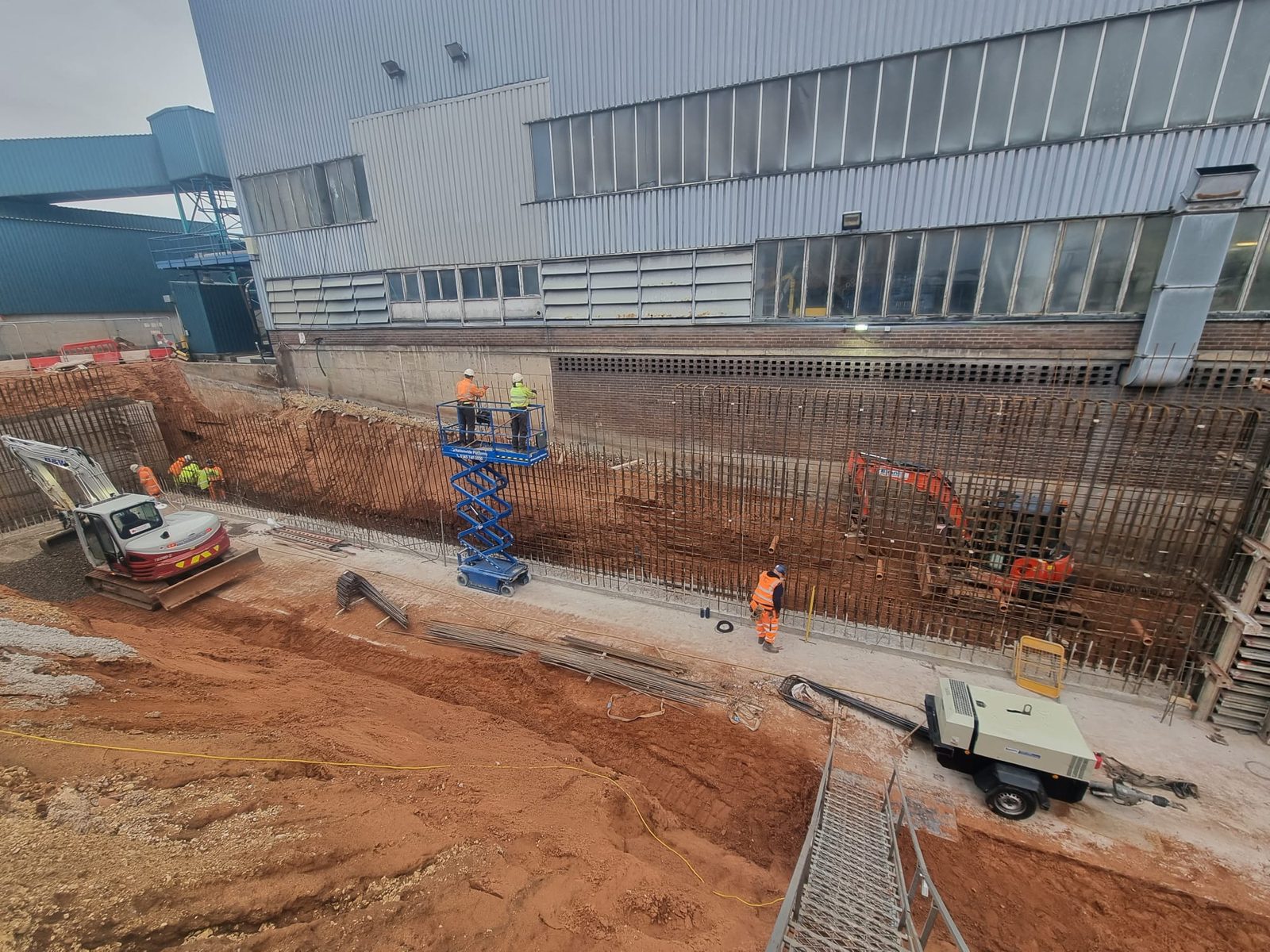 Steel reinforcement fixed for a retaining wall alongside a live industrial building